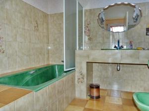 a bathroom with a green tub and a sink at 605 VIlla ocean Atlantique au bout du jardin in Audierne
