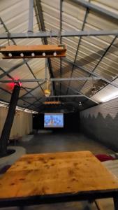 a room with a wooden table and a tv at Luvya Retreats Hotel in Manāli