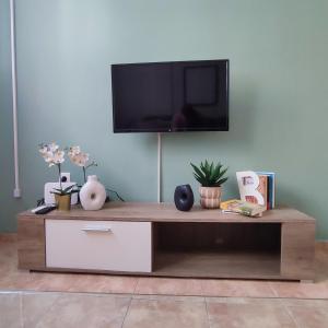 a wooden coffee table with a tv on a wall at Madi01 in Athens