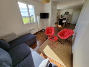 a living room with a couch and two red chairs at 625-VIlla Penzer pour surfer a St Tugen in Primelin