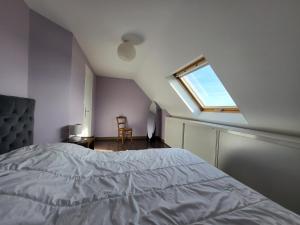 Schlafzimmer mit einem Bett und einem Fenster in der Unterkunft 625-VIlla Penzer pour surfer a St Tugen in Primelin