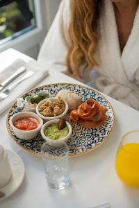 a woman sitting at a table with a plate of food at PALASIET Thalasso Clinic&Hotel in Benicàssim