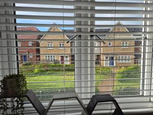 une grande fenêtre avec vue sur un bâtiment dans l'établissement Room in a pristine 4 bed home in Broomfield, à Chelmsford
