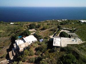 I Dammusi di Punta Karace في تراتْشّينو: اطلالة جوية على المنزل والمحيط