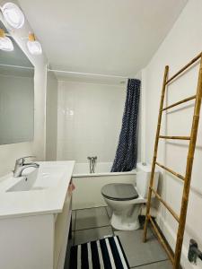 La salle de bains est pourvue de toilettes, d'un lavabo et d'une baignoire. dans l'établissement COCON CENTRAL - Cathédrale & Castillet - Parking Gratuit - Wifi, à Perpignan