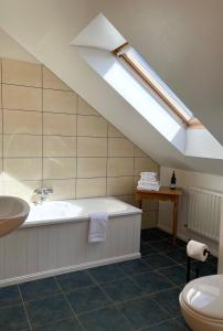 a bathroom with a bath tub and a skylight at Bed & Breakfast - Shanakeever Farm in Clifden