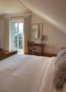 a bedroom with a bed and a desk and a window at Bed & Breakfast - Shanakeever Farm in Clifden