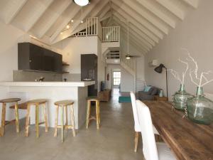 a kitchen and living room with a table and stools at Vista Marina in Kralendijk