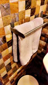 a bathroom with towels hanging on a wall at شقه غروب البحر in Obhor
