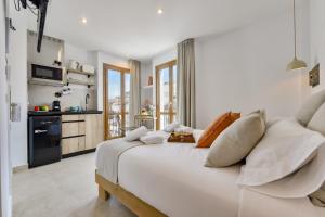 a white bedroom with a large white bed with pillows at MIMAR ALTEA ROOMS in Altea