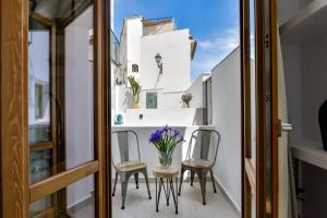 a small balcony with chairs and a vase of flowers at MIMAR ALTEA ROOMS - Tranquil in Altea