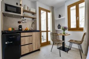 a kitchen with a black refrigerator and a table and chairs at MIMAR ALTEA ROOMS - Tranquil in Altea