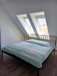 a bed in a room with two windows at Apartmán Marty in Nové Zámky