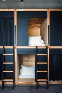 two sets of bunk beds in a room at EN PLUS Sauna and Capsule Bed 男性専用 in Kochi