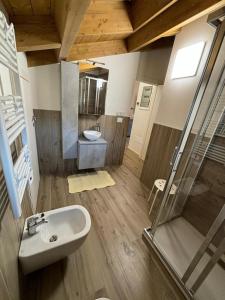 La salle de bains est pourvue d'un lavabo et d'une douche. dans l'établissement APPARTAMENTO ANDREA, à Selvino