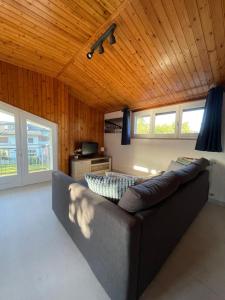un divano in soggiorno con soffitto in legno di Stanza in villa da Alberto a San Giorgio Canavese