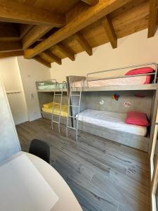 Cette chambre comprend 2 lits superposés et du parquet. dans l'établissement APPARTAMENTO ANDREA, à Selvino