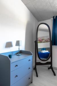 una camera da letto con cassettiera e specchio di Stanza in villa da Alberto a San Giorgio Canavese