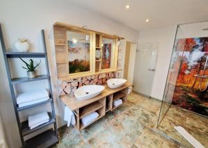 a bathroom with two sinks and a shower at Landgasthof Rebstock in Ottenhöfen