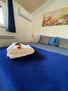 una camera con un letto e un tappeto blu di Stanza in villa da Alberto a San Giorgio Canavese