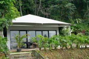 ein kleines Haus mit einem Tisch und einem Stuhl in der Unterkunft Pelangi Park Hotel & Resort in Pasirkuda