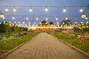 einen Garten mit Beleuchtung und ein Gebäude im Hintergrund in der Unterkunft Pelangi Park Hotel & Resort in Pasirkuda