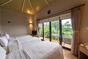 a hotel room with two beds and a large window at Pelangi Park Hotel & Resort in Pasirkuda