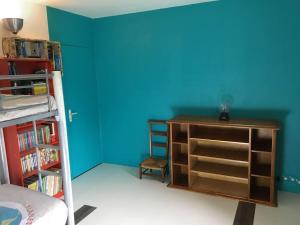 a bedroom with a blue wall and a desk and a bed at Family house Bayeux - DDay in Subles