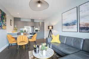 a living room with a couch and a table at Elliot Oliver - Stylish 2 Bedroom Apartment With Parking In The Docks in Gloucester