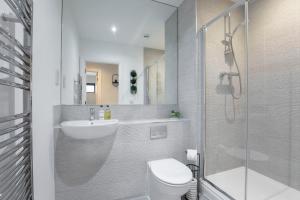 y baño con aseo, lavabo y ducha. en Elliot Oliver - Stylish 2 Bedroom Apartment With Parking In The Docks, en Gloucester