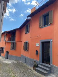 an orange building with a door and stairs outside at B&B Pudzones in Santu Lussurgiu