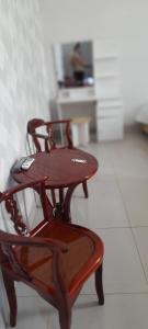 een houten tafel en een stoel in een kamer bij Nhà Nghỉ Kim Cương in Rach Gia