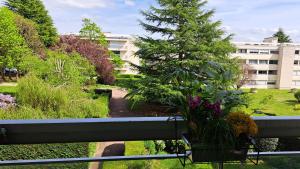 a balcony with a bench and a tree and a building at Appartement de standing a Bailly 78870 in Bailly