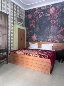 um quarto com uma cama grande e papel de parede floral em Hotel Star INN em Jalandhar
