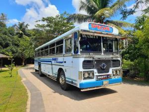 a blue and white bus parked on a street at ROYAL GRAND PARADISE RESORT AND TOURS NEAR COLOMBO in Kelaniya