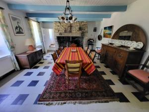 ein Esszimmer mit Tisch und Stühlen und einem Kamin in der Unterkunft 607-Manoir de Pompren in Esquibien
