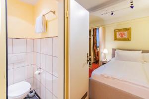 baño pequeño con cama y ducha en Hotel Weiler en Oberwesel