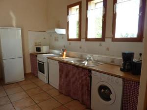 eine Küche mit einer Spüle und einer Waschmaschine in der Unterkunft Gîte de l'Ivronnière in La Ronde