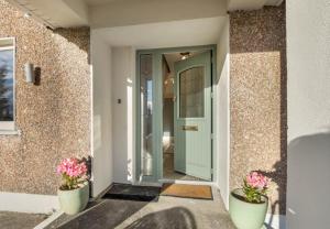 uma porta da frente de uma casa com dois vasos de plantas em Teach Eile, Clifden em Clifden