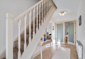 uma escadaria numa casa com paredes brancas e pisos brancos em Teach Eile, Clifden em Clifden