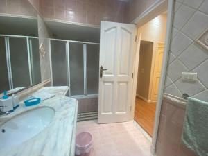 ein Badezimmer mit einem Waschbecken, einer Dusche und einer Badewanne in der Unterkunft Garden city 3 bedroom apartment in Kairo