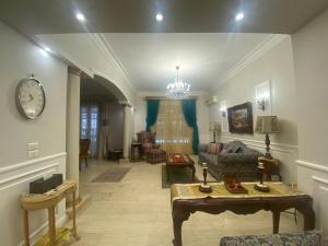 - un salon avec un canapé et un réveil sur le mur dans l'établissement Garden city 3 bedroom apartment, au Caire