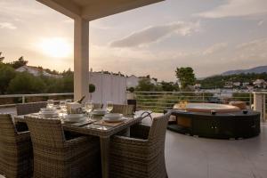 eine Terrasse mit einem Tisch und einer Badewanne auf einem Balkon in der Unterkunft Villa Kora - luxury holiday Apartments in Lumbarda