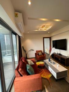 uma sala de estar com um sofá vermelho e uma mesa em CozyLuxury apartment solaris em Acra
