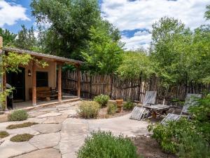 a patio with two chairs and a wooden fence at El Nido Lane Tesuque, 1 Bedroom, Sleeps 2, Private Yard, WiFi, Washer/Dryer in Santa Fe