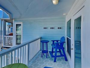 - une terrasse couverte avec 2 chaises et une table sur un balcon dans l'établissement Seascape 1313 - Pineapple Island, à Galveston
