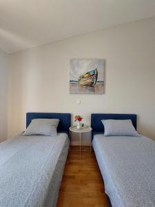 two beds sitting next to each other in a bedroom at Apartments Miletić in Ždrelac