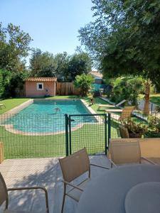 - une piscine dans une cour avec une table et des chaises dans l'établissement villa serignan, à Sérignan