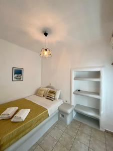 biała sypialnia z łóżkiem i lampką w obiekcie Lorentzo Rooms w mieście Kionia