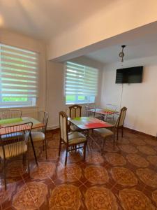 a dining room with tables and chairs and windows at Vila Onix in Sovata